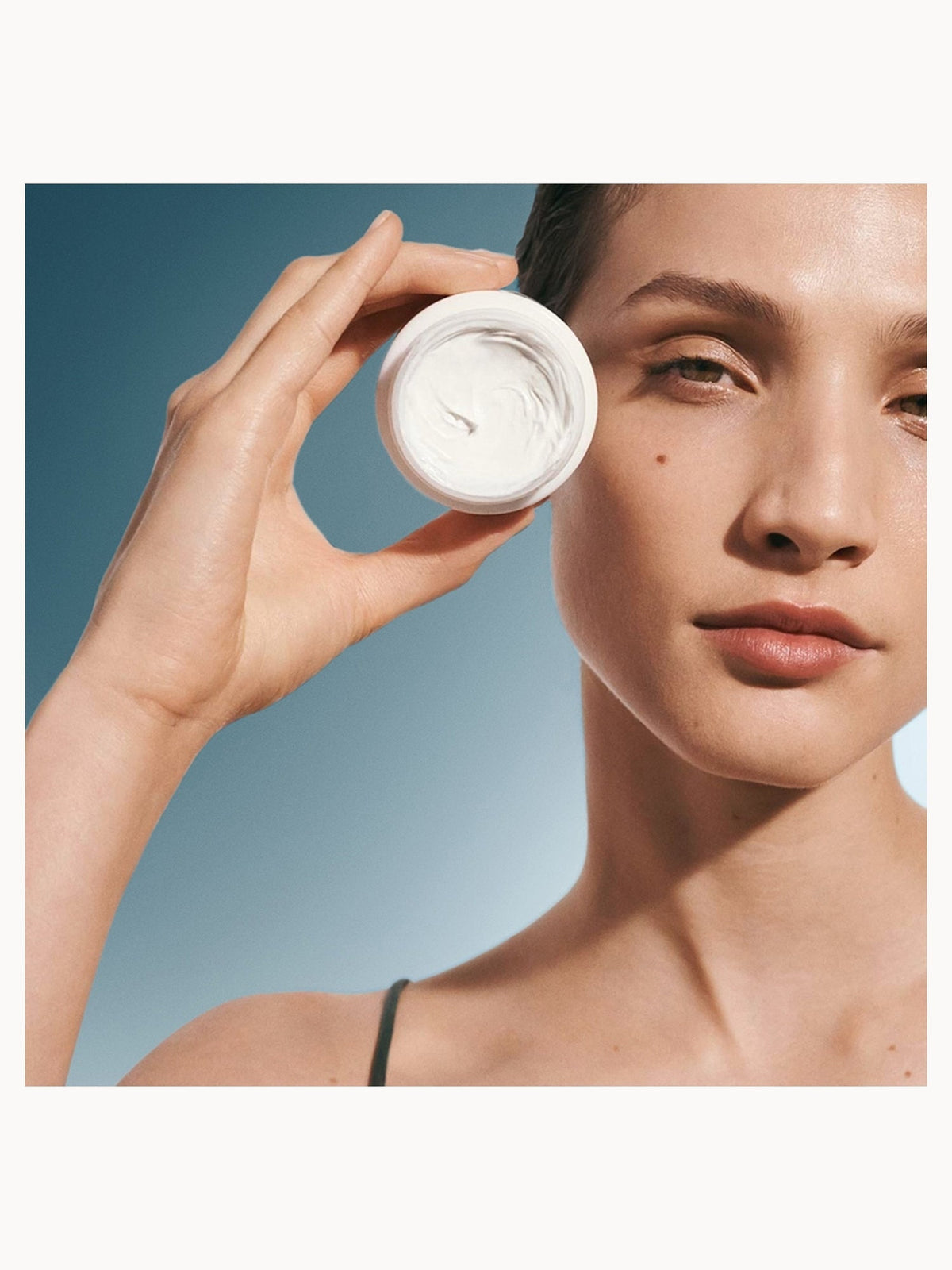 Crème de la Mer The Moisturising Cream held to the face