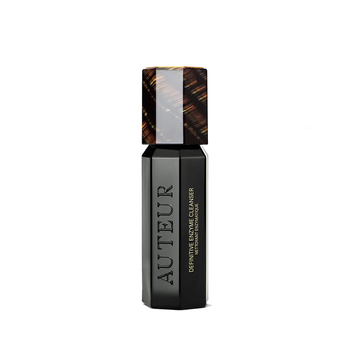 A bottle of Auteur Definitive Enzyme Cleanser with a dark liquid and a cap, on a white background.