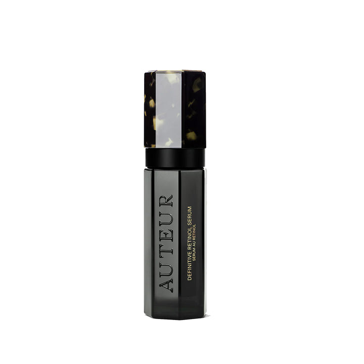 A bottle of Auteur Definitive Retinol Serum with a black and patterned cap, labeled with the brand's logo.