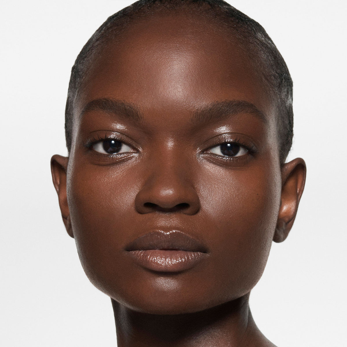 Model wearing Victoria Beckham Beauty The Foundation Drops in shade 16 Deep