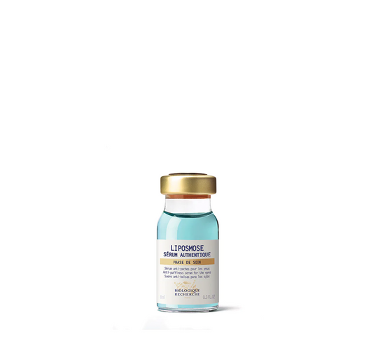 A clear glass vial with a gold cap labeled as 'Liposmose Biologique Recherche Serum' used for the eye contour area.
