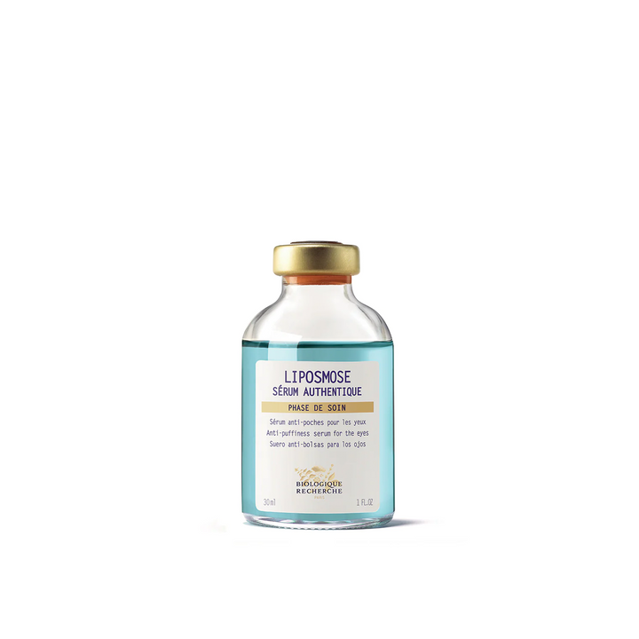 A clear glass vial with a gold cap labeled as 'Liposmose Biologique Recherche Serum' used for the eye contour area.