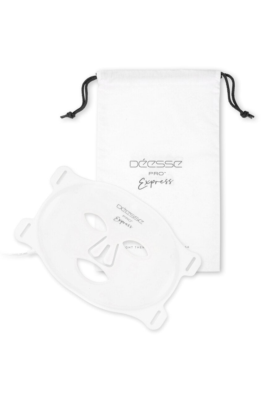 A white silicone flexible LED light therapy mask with the brand name Deèse Pro Express visible on it. The mask is presented in a pull-out box with a drawstring re-usable bag, along with a power cord, USB re-chargeable control unit, and other accessories.