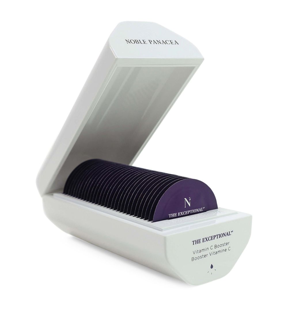 A white, compact container with a purple lid, labeled as 'Noble Panacea Vitamin C Booster Serum', containing individual sachets.
